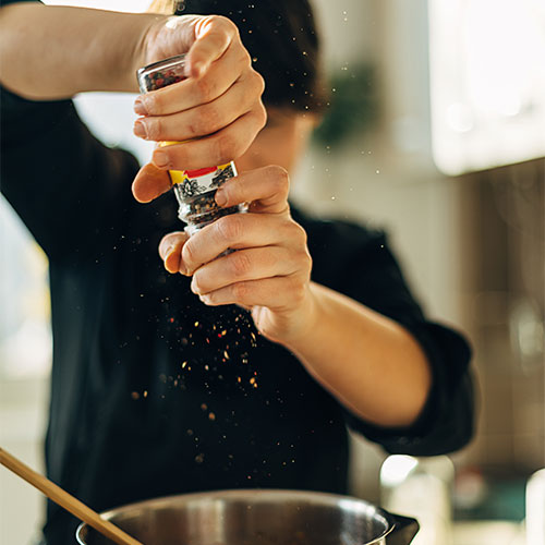 woman cooking with black pepper