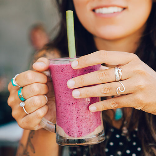 A woman holding a smoothie.