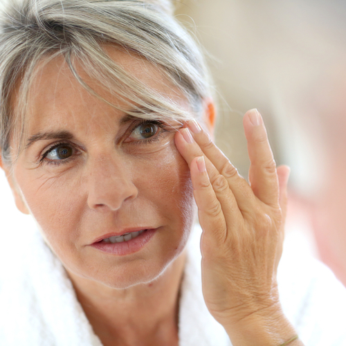 older woman touching face