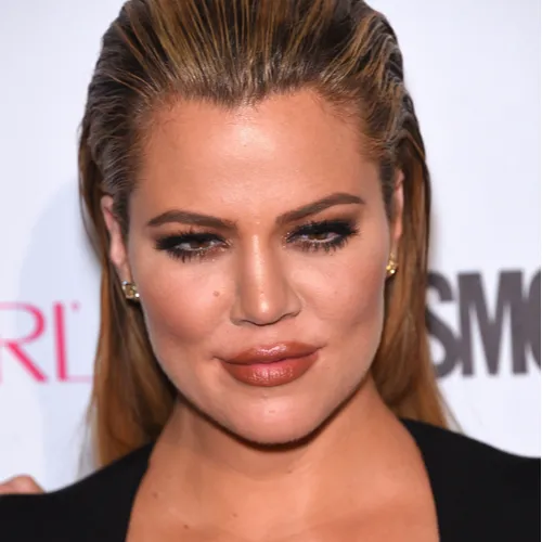 Khloe Kardashian smiling in a casual setting.