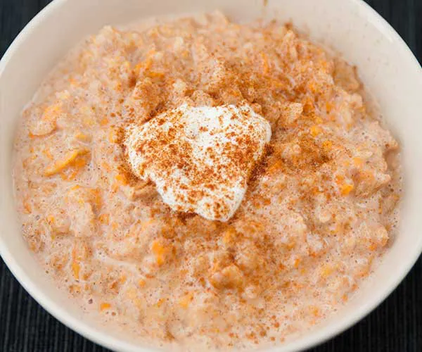 Creamy oatmeal bowl garnished with berries and honey.