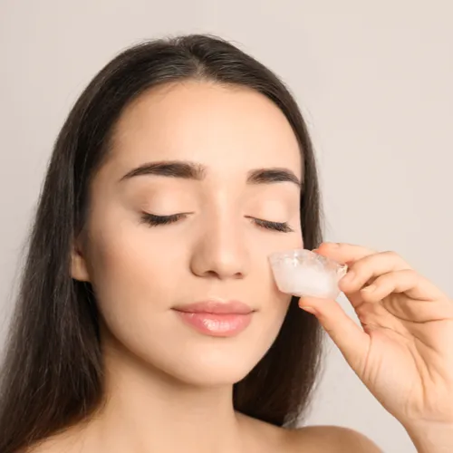 woman putting ice on face