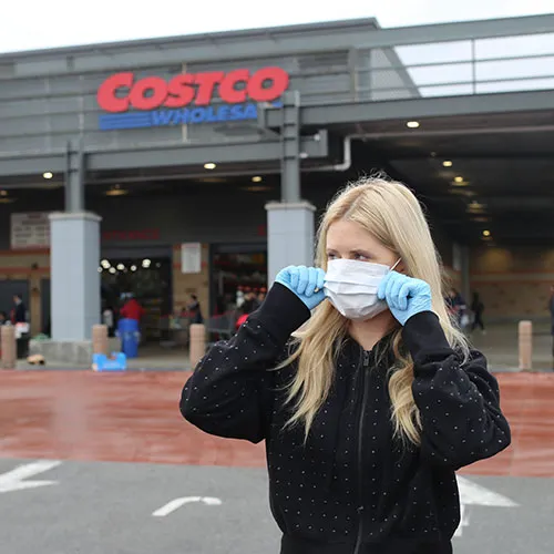 Shoppers exploring aisles in a Costco warehouse.
