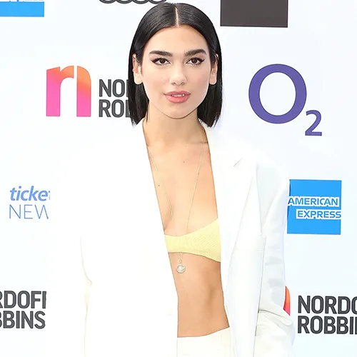Dua Lipa wearing a fashionable ensemble with vibrant colors.