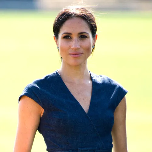 Meghan Markle smiling in a stunning outfit at a public appearance