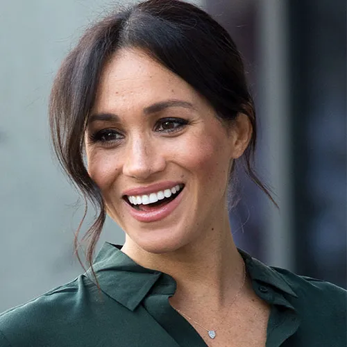 Meghan Markle posing confidently in a fashionable ensemble