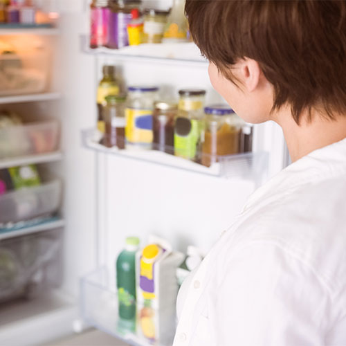 woman looking in fridge