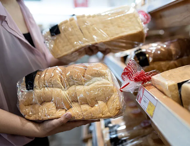 Freshly packaged white sandwich bread loaves on display.