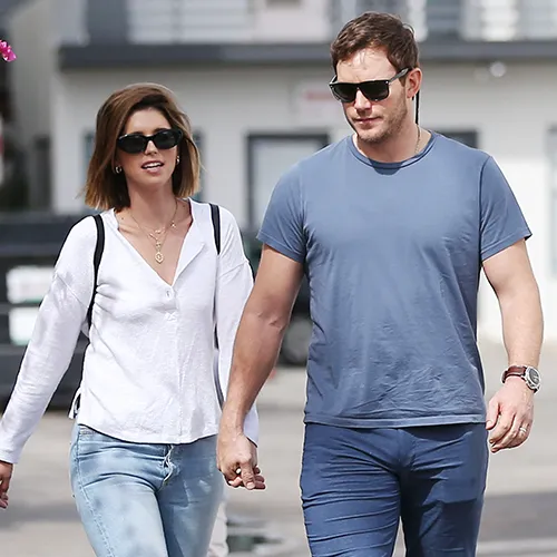Katherine Schwarzenegger and Chris Pratt walking hand-in-hand at a gathering.