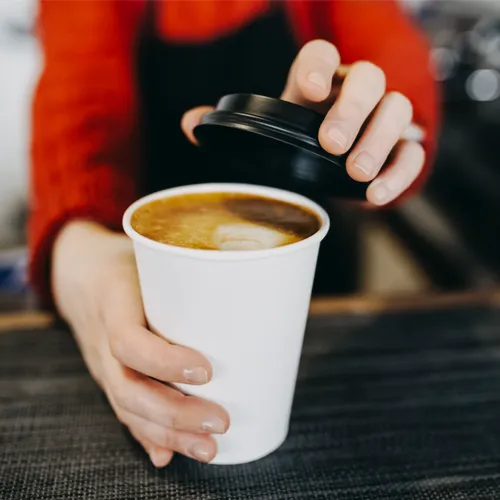 barista handing over coffee cup