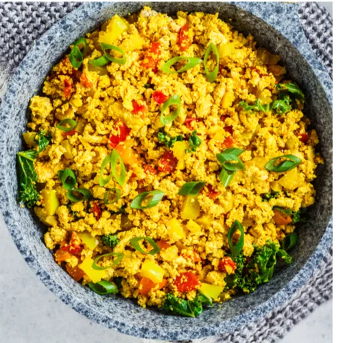 "Scrambled eggs with vegetables in a skillet"