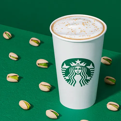 Starbucks pistachio latte in a cozy cafe setting.