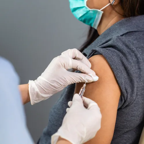 Healthcare professional administering COVID-19 vaccine.