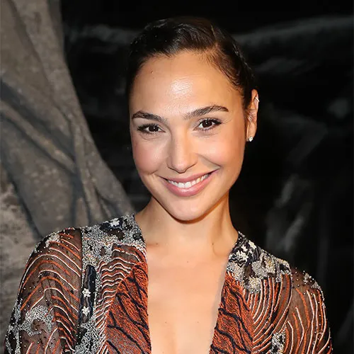 Gal Gadot smiling confidently at a movie premiere.