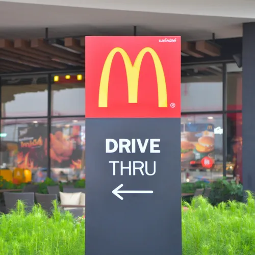 McDonald's drive-thru lane with illuminated signage.