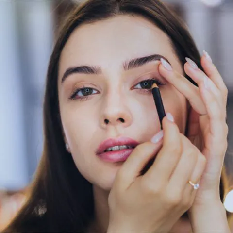 woman applying eyeliner