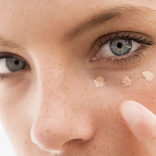 "Close-up of a woman applying concealer"