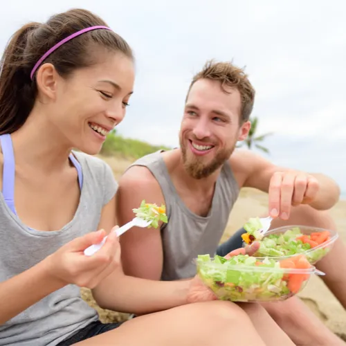 woman and man eating salads