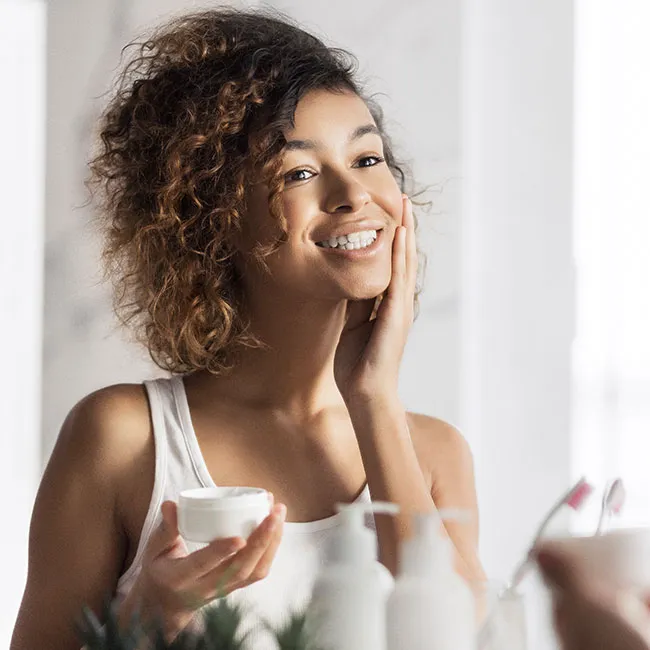 "Young woman applying sunscreen for skin protection"