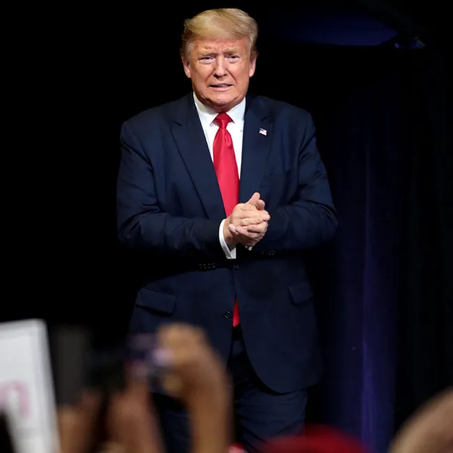 Donald Trump speaking on stage at a public event.