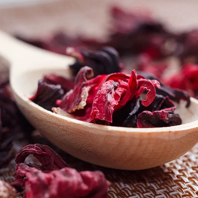 Dried hibiscus tea leaves in a glass jar.