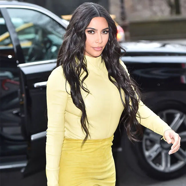 Kim Kardashian in a chic yellow turtleneck outfit.