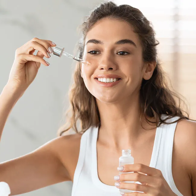 Applying retinol cream while looking in the mirror.