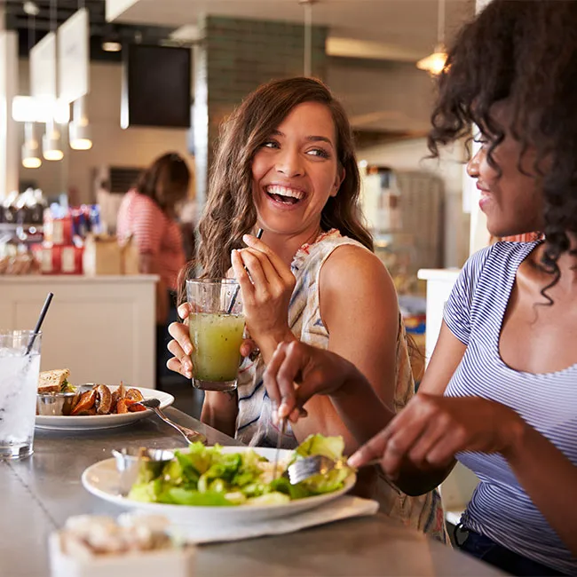 Two female friends enjoying a healthy lunch together.