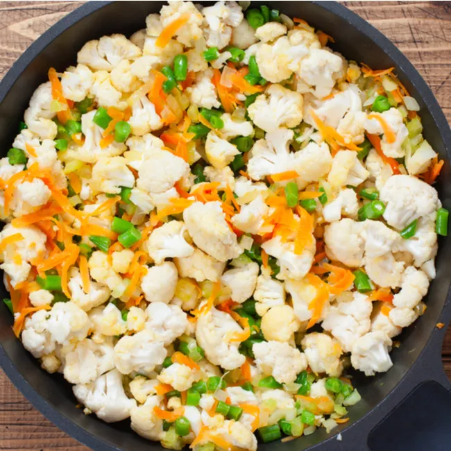 Preparing cauliflower stew with fresh ingredients and spices