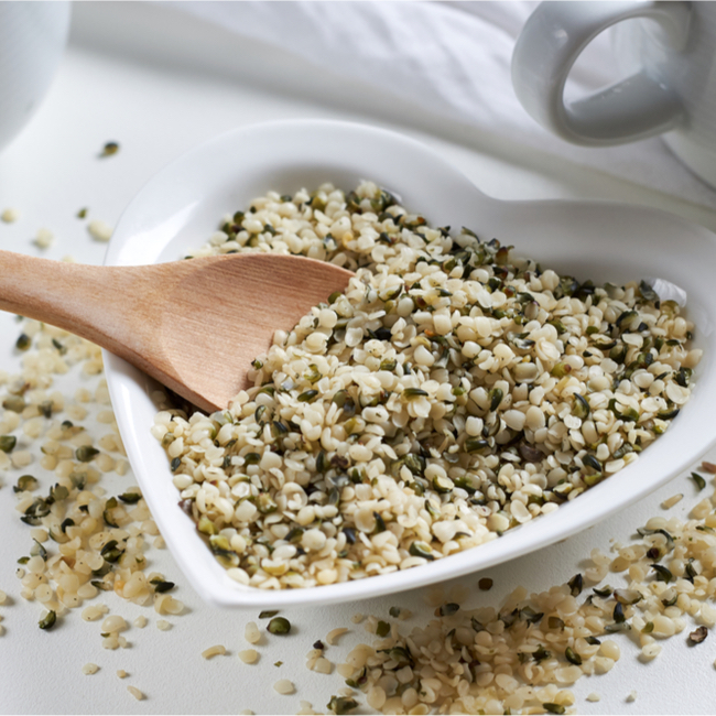 hemp seeds in heart-shaped bowl with spoon