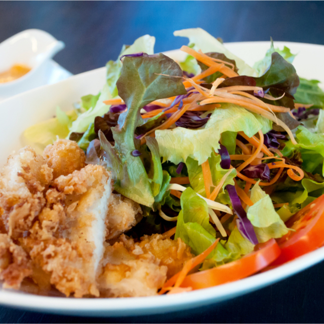 salad topped with fried chicken