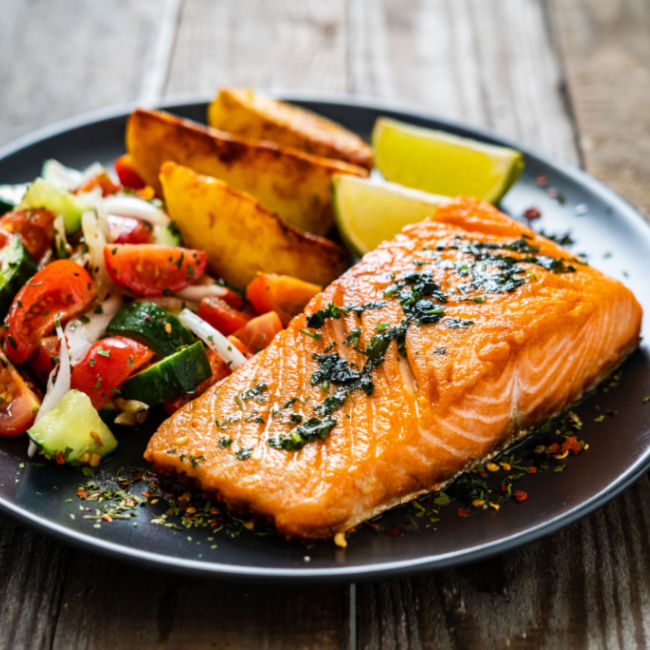 salmon, potato wedges, and veggies on plate