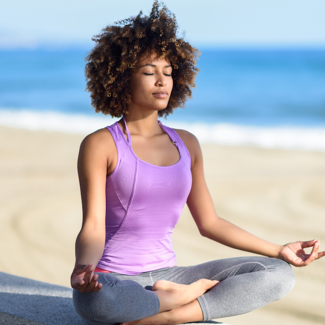 woman meditating on beach