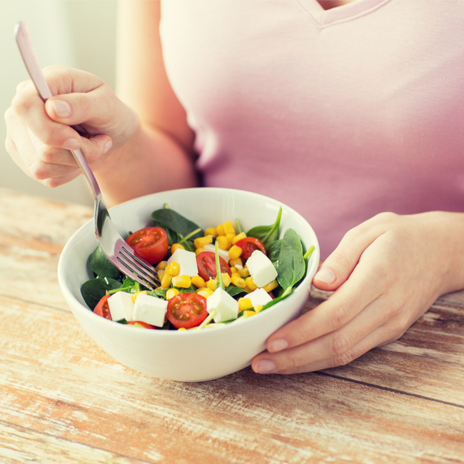 woman eating healthy salad with a fork