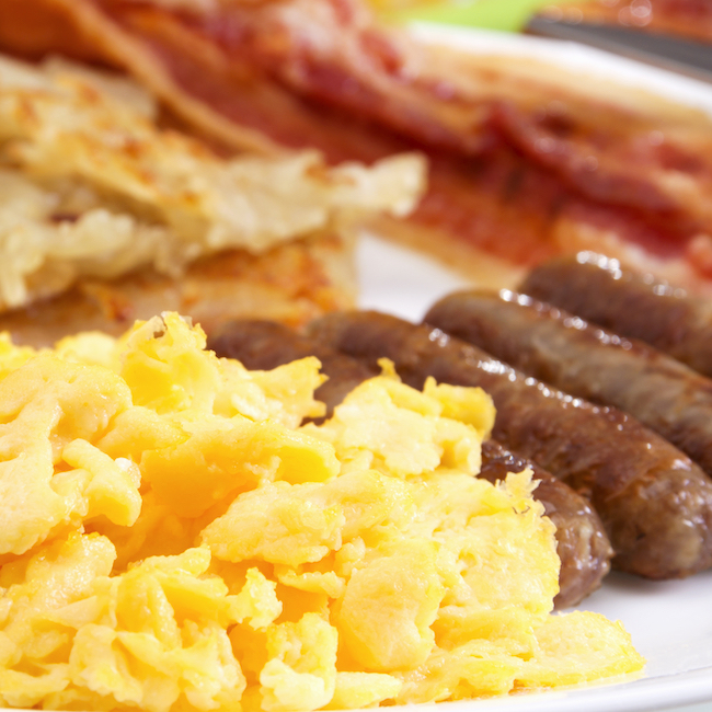 bacon, sausage links, eggs, and hash browns on a plate