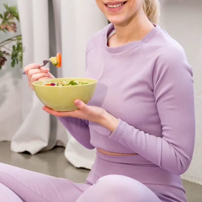 Healthy meal bowl with workout clothes ready for exercise.
