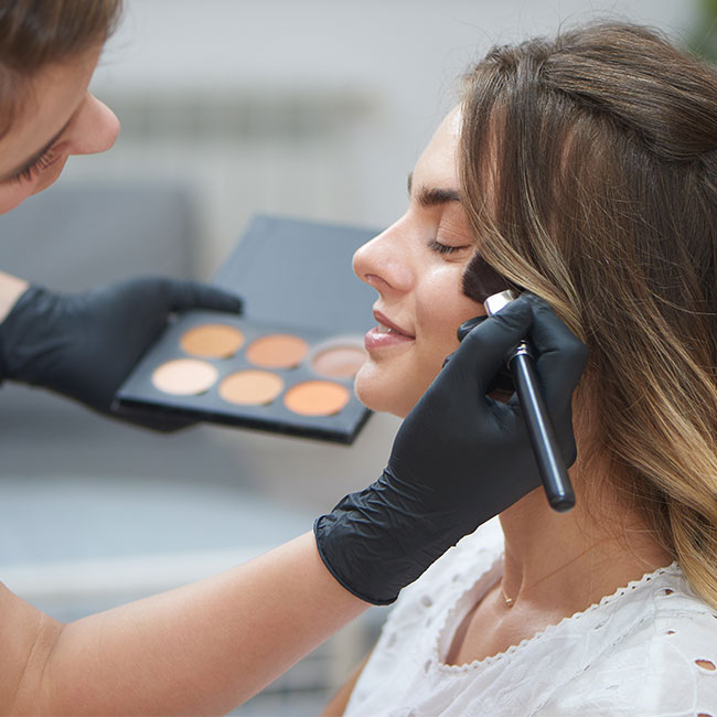 makeup artist applying contour to a woman's face
