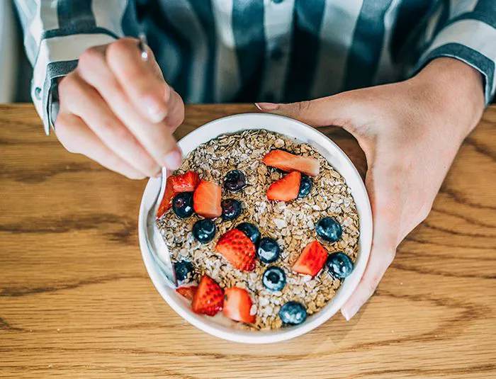 Woman eating oatmeal with berries