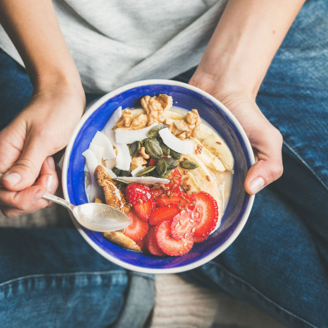 woman eating healthy breakfast bowl