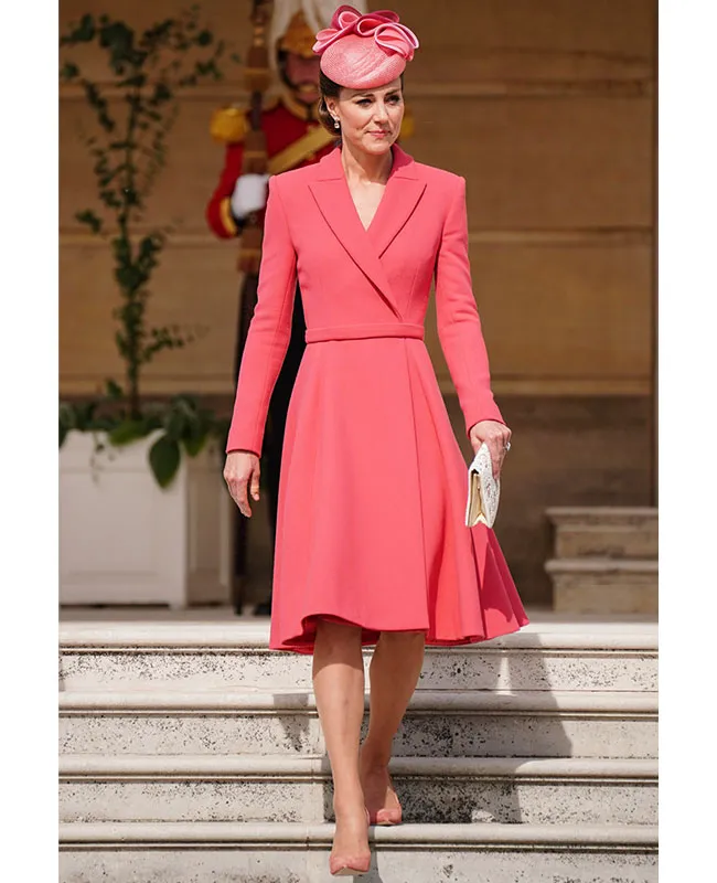 Kate Middleton in a stylish coral dress at an event.