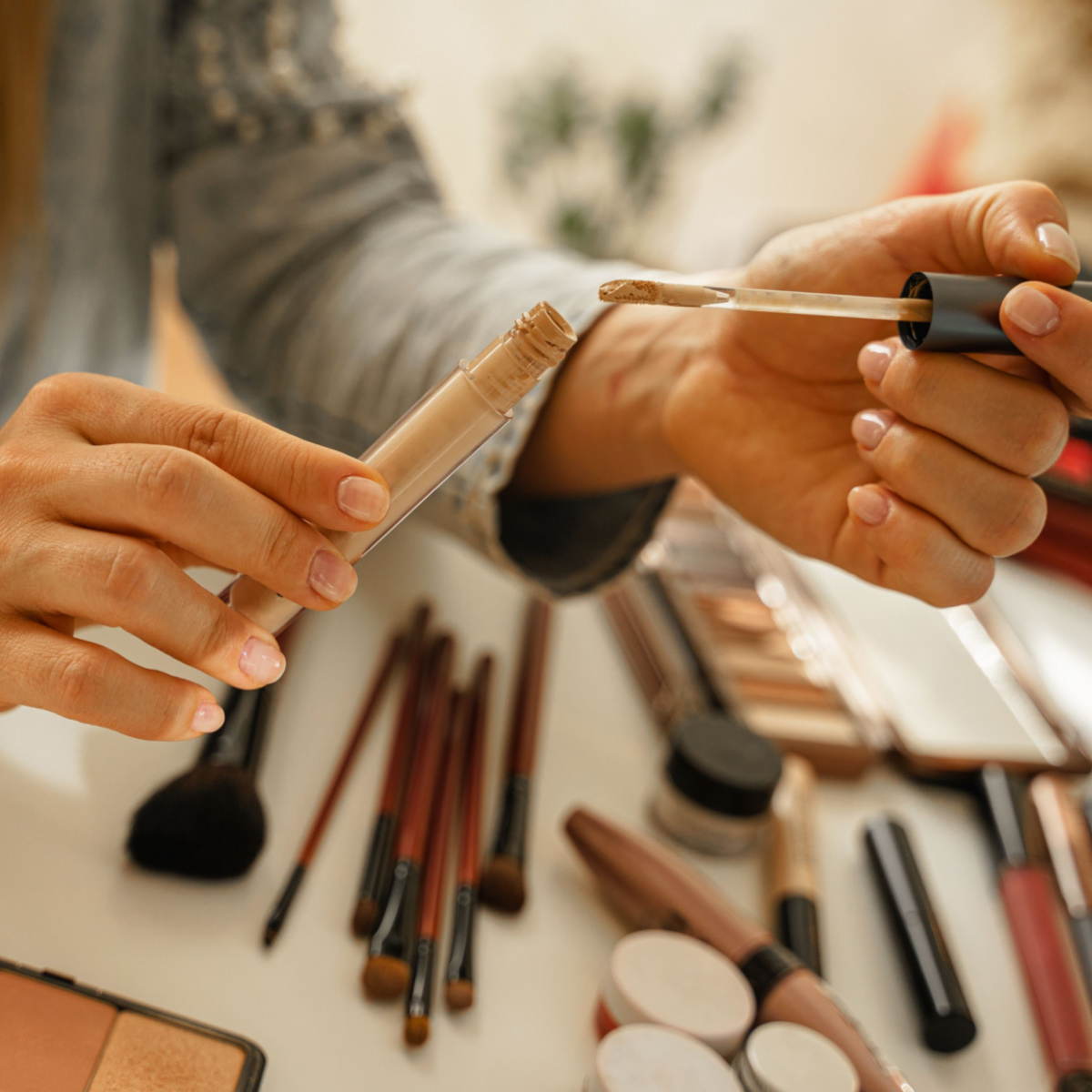 woman testing out concealers makeup products on a white surface wrist