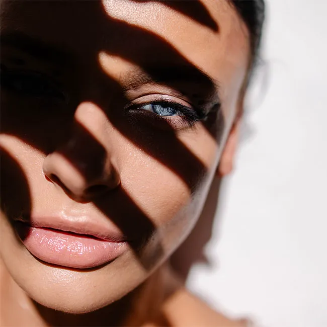 "Blue-eyed woman covering her face with shadow"