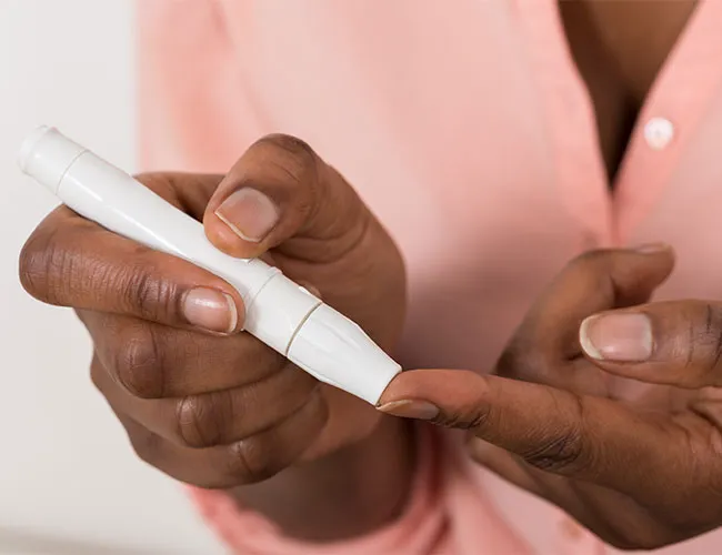 "Person performing a blood sugar test using a finger prick"