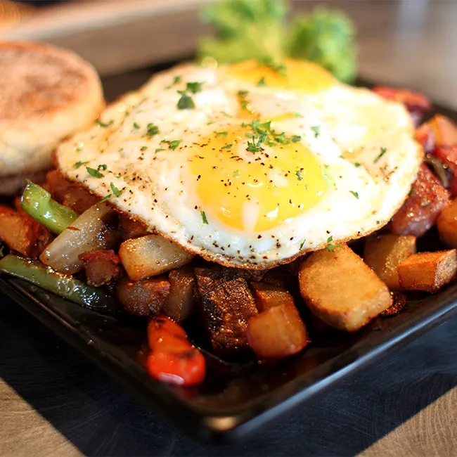 Breakfast plate with eggs and seasoned potatoes.