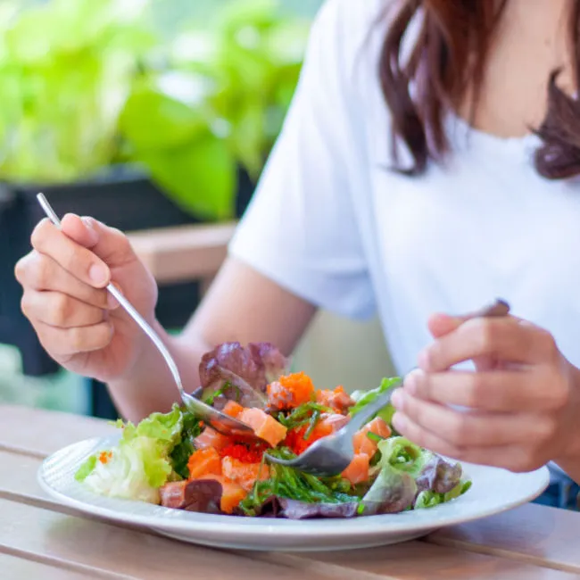 Fresh salad being enjoyed at a dining table.
