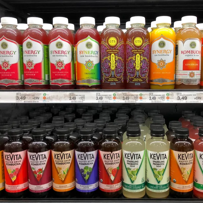Shelves stocked with various kombucha flavors and brands