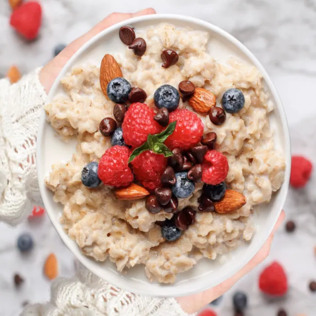 Bowl of oatmeal topped with fresh fruits and nuts