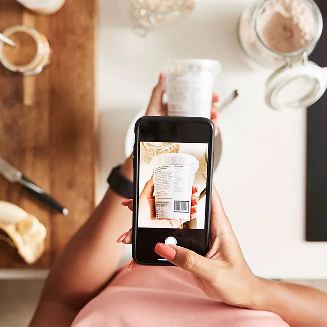 Woman using macro counting app to scan food.