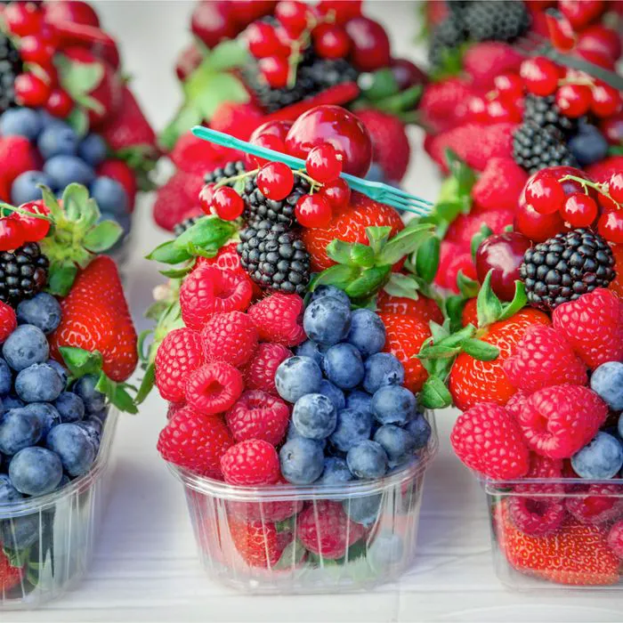 Fresh berries displayed in a vibrant grocery store.