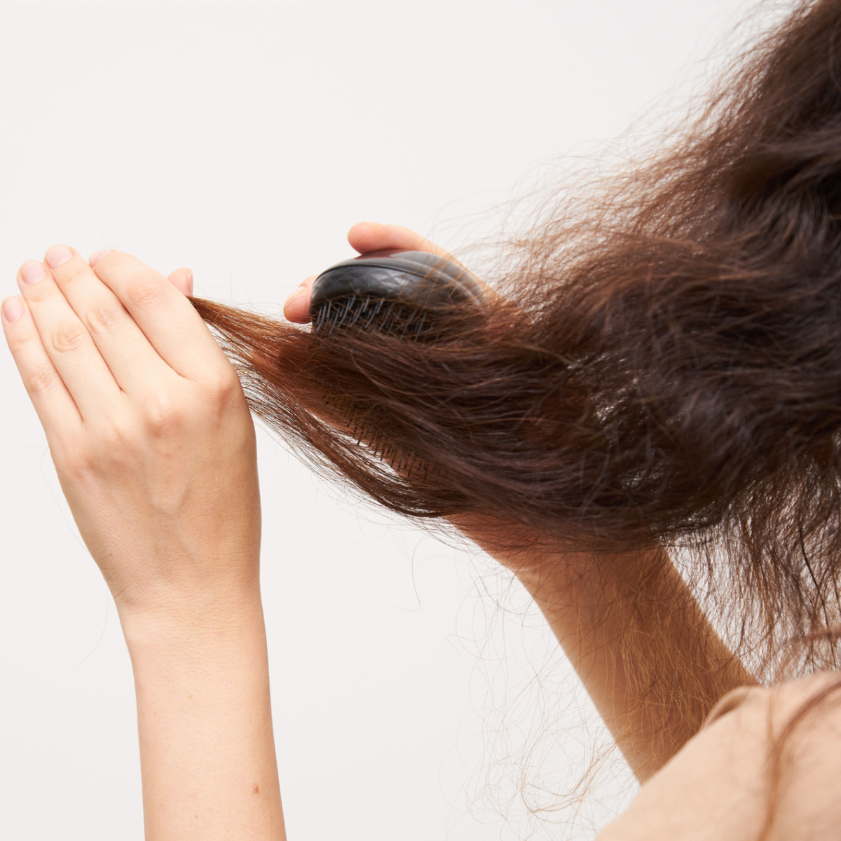 woman brushing frizzy long hair split ends